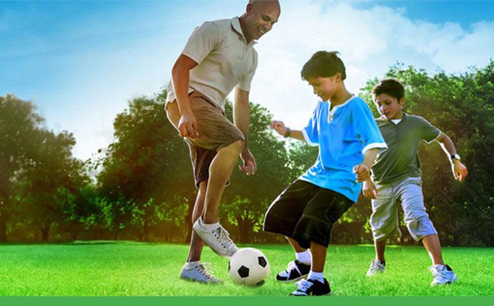 A Father playing soccer with his children